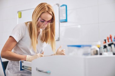 Çekmeceleri karıştıran özenli sarışın kadın.