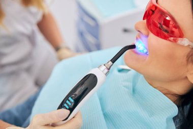 Elinde dişçilik malzemesi olan kadınlara odaklanmış bir fotoğraf.