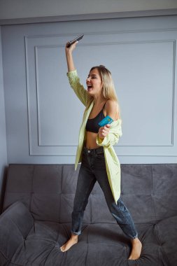 Gülen kadın elinde banka kartıyla el sallıyor.