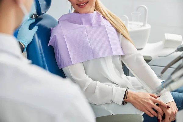 Persona sonriendo a un profesional dental desde una silla — Foto de Stock