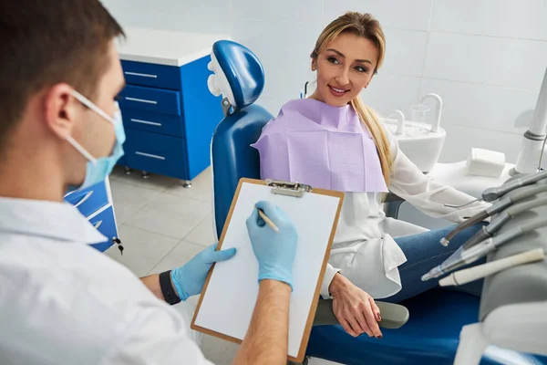 Mujer describiendo sus problemas a la escritura dentista — Foto de Stock