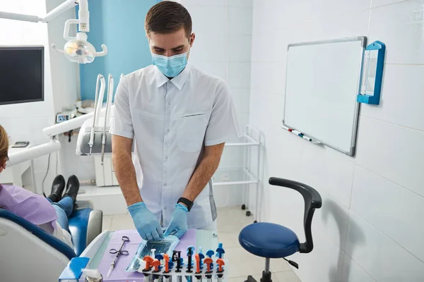 Dentista dessellando un paquete con instrumentos dentales estériles — Foto de Stock