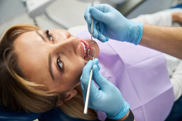 Espejo dental y explorador en una boca femenina — Foto de Stock