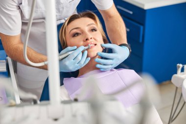 Dişçi kadın dişlerini el yazısıyla temizliyor.