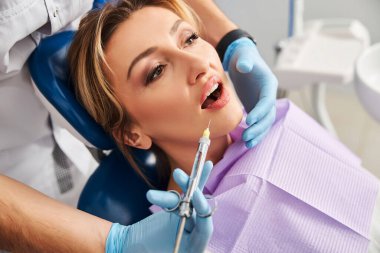 Sağlık çalışanı diş şırıngası enjekte ediyor.