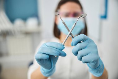 Diş aynası ve sonda dişçi tarafından çaprazlanıyor.