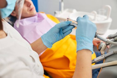 Sıhhiye merhemi sürme fırçası üzerine dikkatle yayıyor