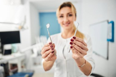 Bir dişçi tarafından sunulan ağız aynası.