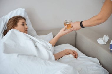 Nazik esmer kadın çayla bardağa bakıyor.