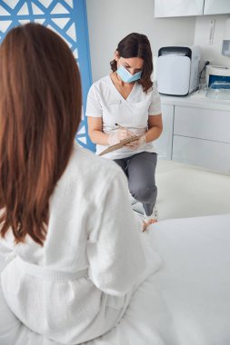 Klinikte hastayla görüşen hoş bir bayan doktor.