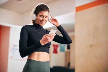 Sportif bayan sabah egzersizleri için şarkı seçiyor.