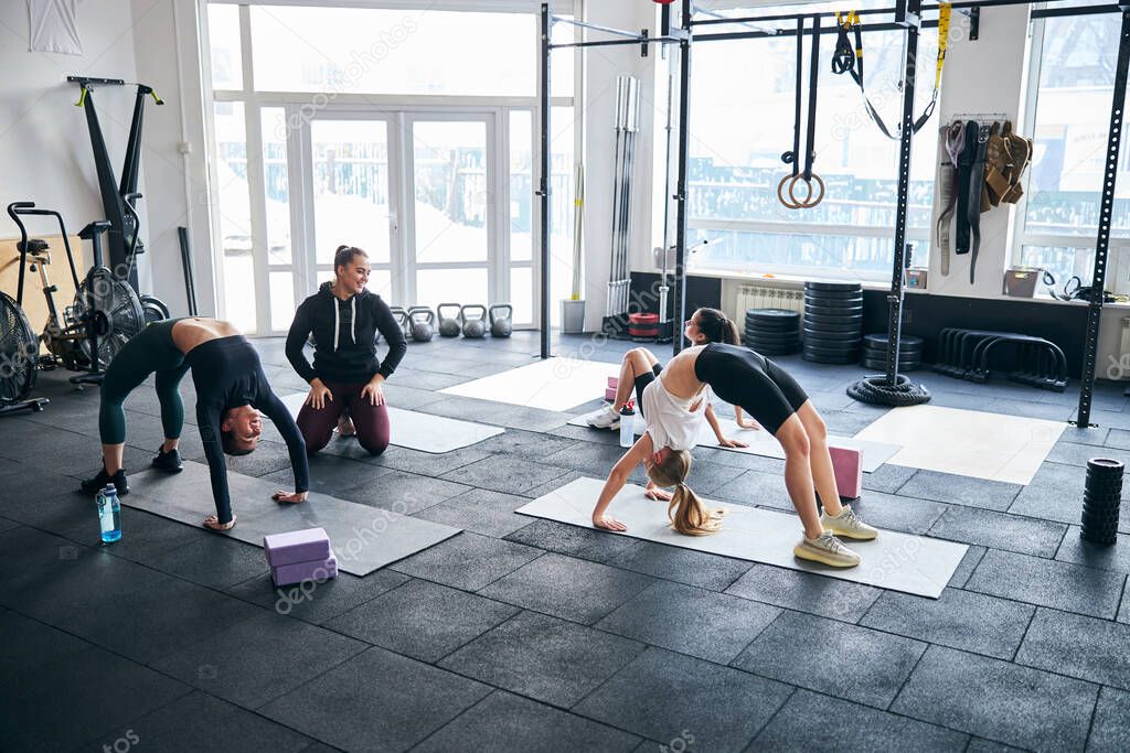 Pleased woman witnessing her gym partners excel at exercising