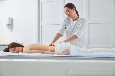 Masör beline parmak eklemleriyle baskı yapıyor.