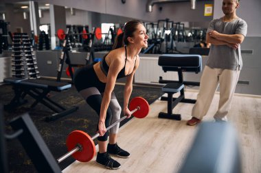Genç esmer kadın fitness eğitmeniyle çalışıyor.