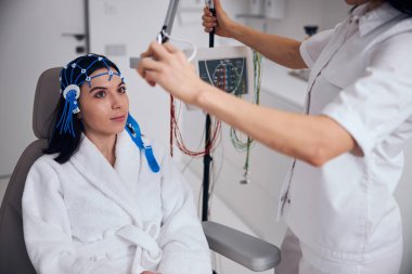 Tıbbi bir işlemden önce sandalyeye oturan sakin bir hasta.