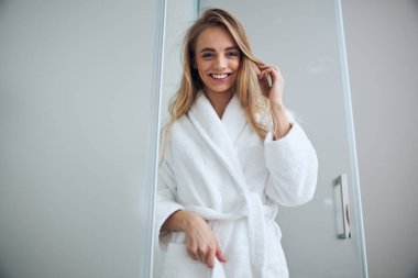 Banyonun kapısında duran mutlu bayan.