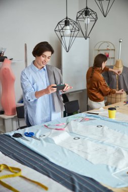 Akıllı telefonu olan kişi desenlerin ve kumaşların fotoğrafını çekiyor