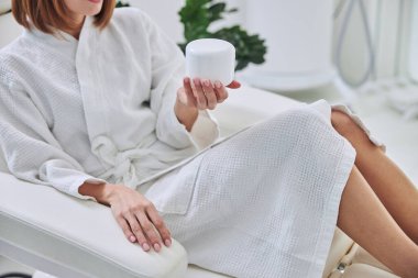 Güzeller güzeli kadın kozmetolog kabinesinde dinleniyor.