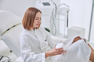 Neşeli beyaz kadın spa tatil köyünde vakit geçiriyor.