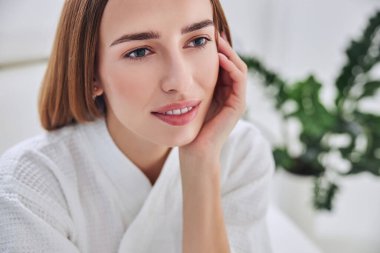 Güzel gülüşü olan genç ve çekici bir bayan spa tatil köyünde dinleniyor.