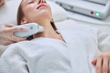 Güzellik uzmanları spa salonunda spa tedavisi yaparken enfes zarif bir kadın spa gününün tadını çıkarıyor.