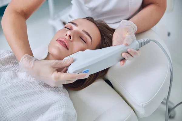 Hermosa mujer joven que recibe lifting facial profesional no quirúrgico en el salón de spa — Foto de Stock