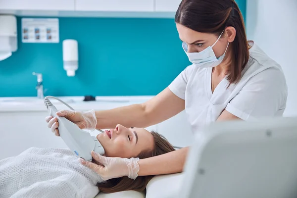 Prachtige elegante blanke dame in witte badjas krijgen verjonging procedure in schoonheidskliniek — Stockfoto