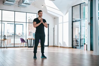 Atletik erkek boş odada namaz kılıyor.