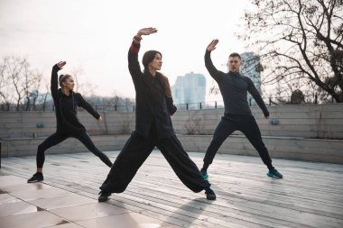 Tai Chi Hoca ve öğrencileri çatıda çalışıyor.