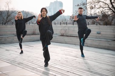 Tai Chi pratikçileri çatıda tek ayak üzerinde dengede duruyorlar.