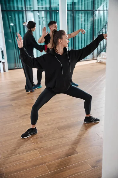 Young female trying to perform tai chi stance — Stock Photo, Image