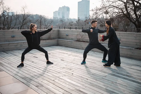 Los atletas que practican wushu posan con el profesor corrigiéndolos —  Fotos de Stock