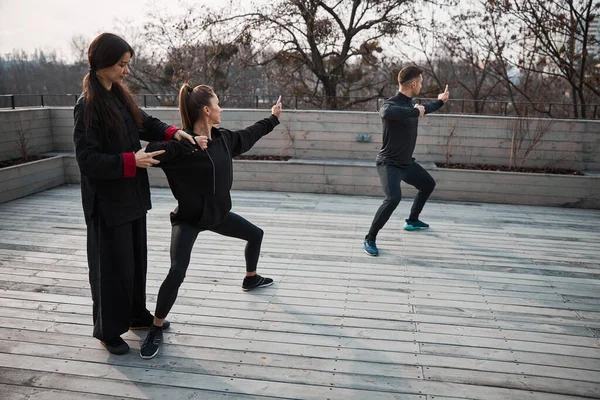 Figyelmes kung fu tanár, aki kijavítja a diákpózt. — Stock Fotó