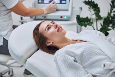 Güzellik dolabında kameraya poz veren mutlu, genç bir bayan.