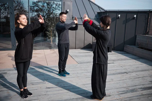 A kung fu oktató hivatalos üdvözlő gesztussal fejezi be az órát. — Stock Fotó