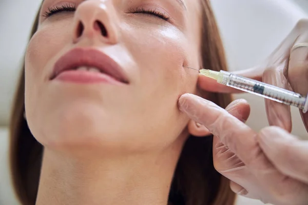 Beautiful young Caucasian female getting hyaluronic aced skincare in cosmetic clinic — Stock Photo, Image