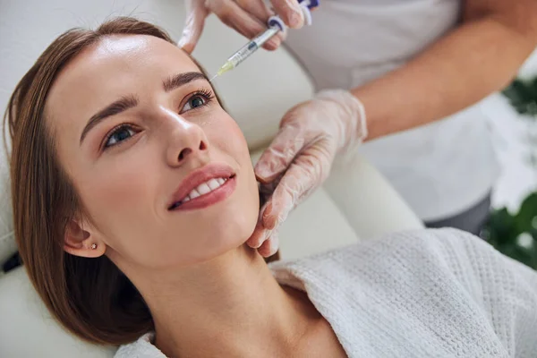 Schöne junge Kaukasierin bekommt Mundkonturierung mit Füllstoffspritze im Wellness-Salon — Stockfoto