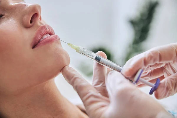 Charming female getting hyaluronic acid skincare in cosmetic salon — Stock Photo, Image