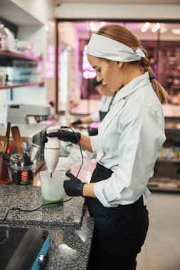 Concentrated confectioner preparing green substance for pastries