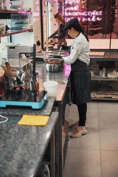 Skilled woman in chef uniform working on tasty treats — Stok fotoğraf