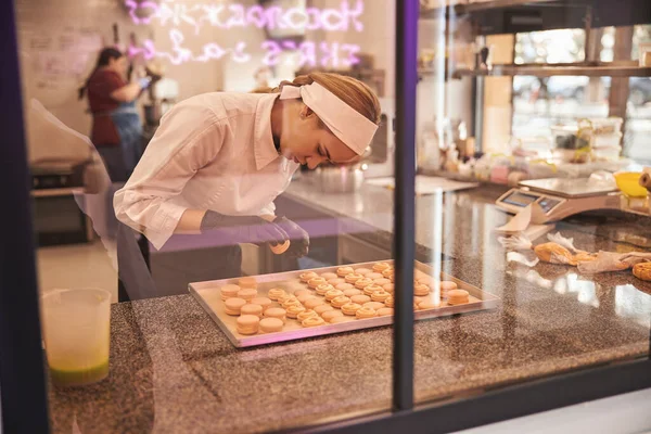 Enthusiastic pastry cook making macarons with passion and concentration — Stok fotoğraf