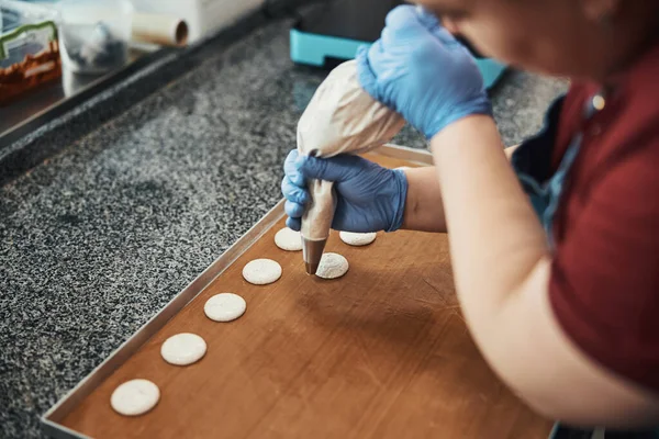 Busy pastry chef making even circles of icing — Stockfoto