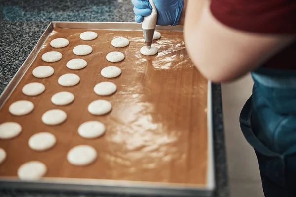 Skilled confectioner with a syringe preparing base for macarons — Stok fotoğraf