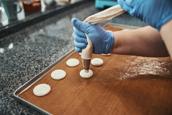 Talented confectioner using syringe for making batter dots — Stok fotoğraf