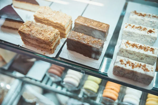 Stücke von verschiedenen Desserts unter dem Glas aufgereiht — Stockfoto