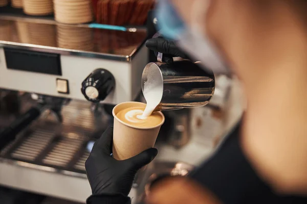 Ικανός barista δημιουργώντας ένα λεπτό μοτίβο στην επιφάνεια latte — Φωτογραφία Αρχείου