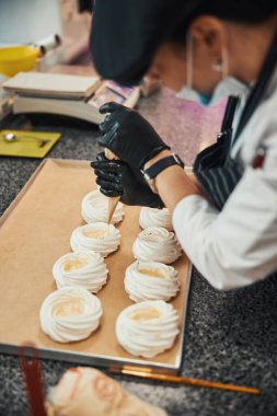 Pasta şefi kremayla süsleme yapıyor.