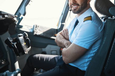 Gündüz vakti işyerinde memnun yakışıklı bir pilot.