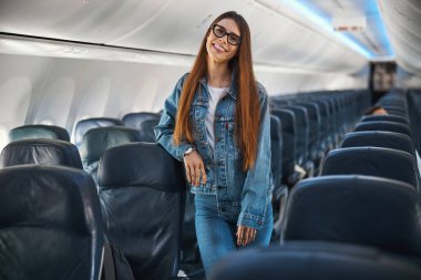 Boş bir uçakta poz veren uzun saçlı bir kadın