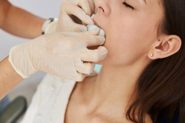 Ellerini dişinin üst çenesine bastır.